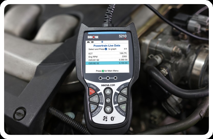 Close-up of a Bluetooth OBD2 scanner plugged into a car's OBD2 port, ready for wireless diagnostics