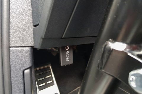 Another angle of the Carly OBD II scanner plugged into a car's OBD port