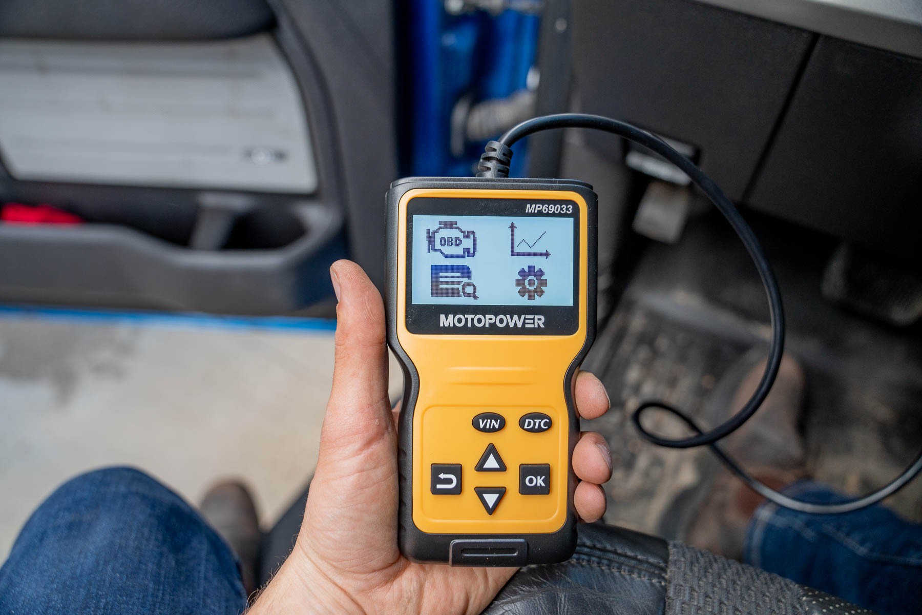 User holding an OBD2 scanner, emphasizing portability and ease of handling