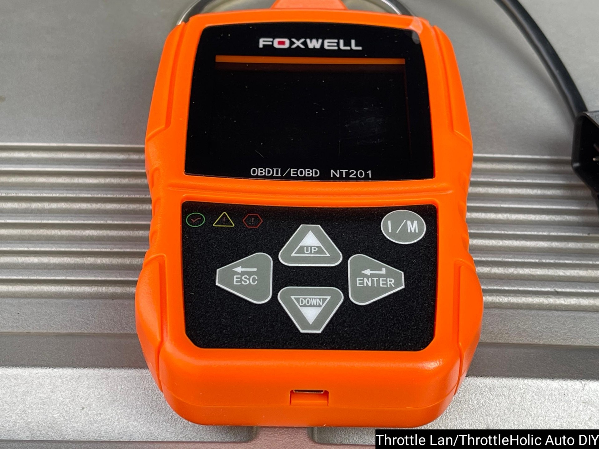 Foxwell NT201 OBD2 Scanner on a car dashboard