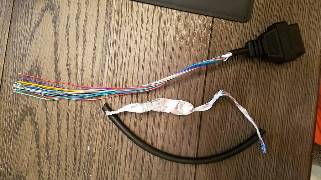 OBD2 cable with sheath and shielding removed to access internal wires for modification.