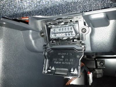 An OBD-II port in a car, used to connect diagnostic software.