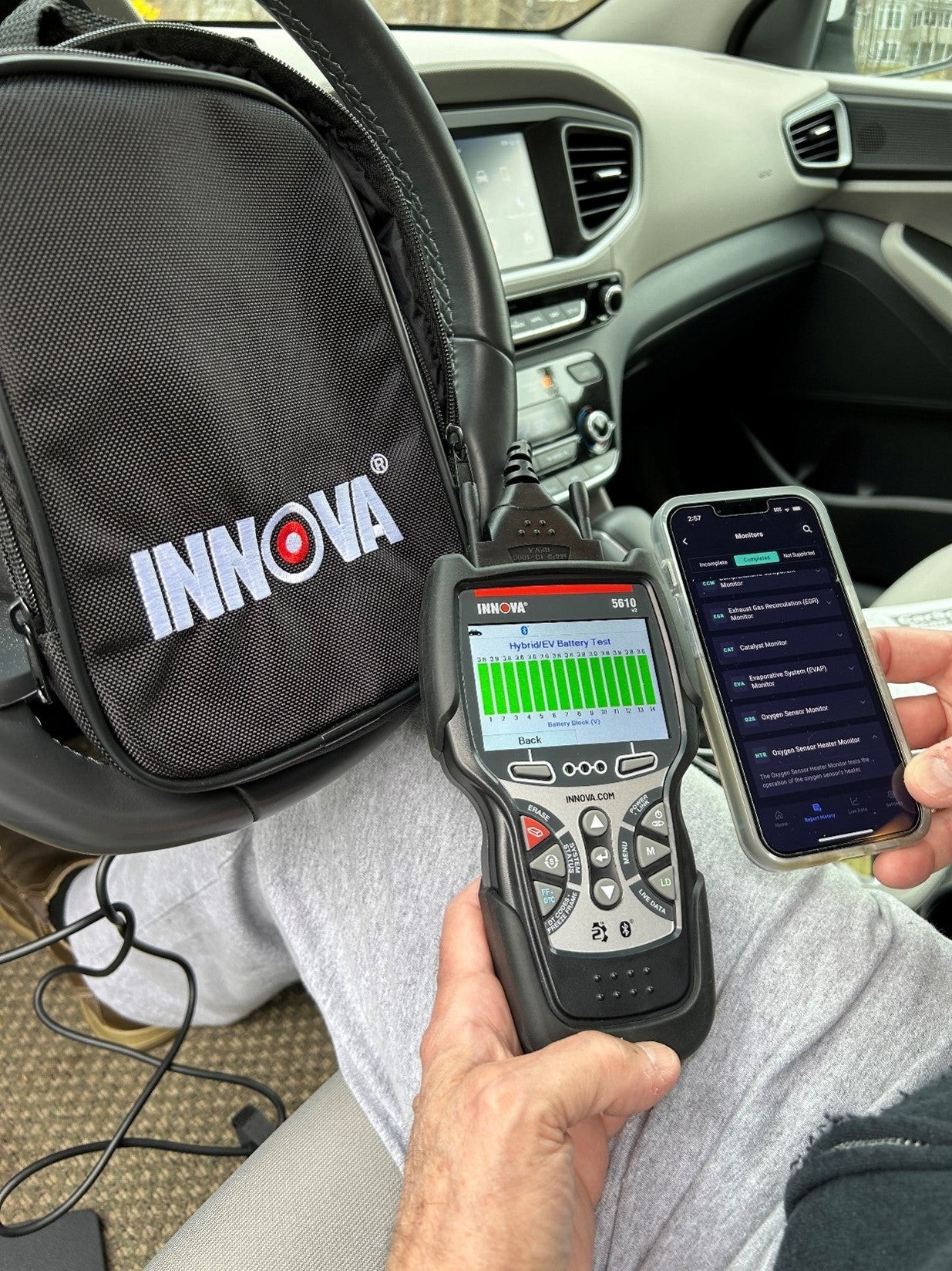 Using an OBD2 scanner to diagnose hybrid car battery issues, as shown with the Innova 5610 model.